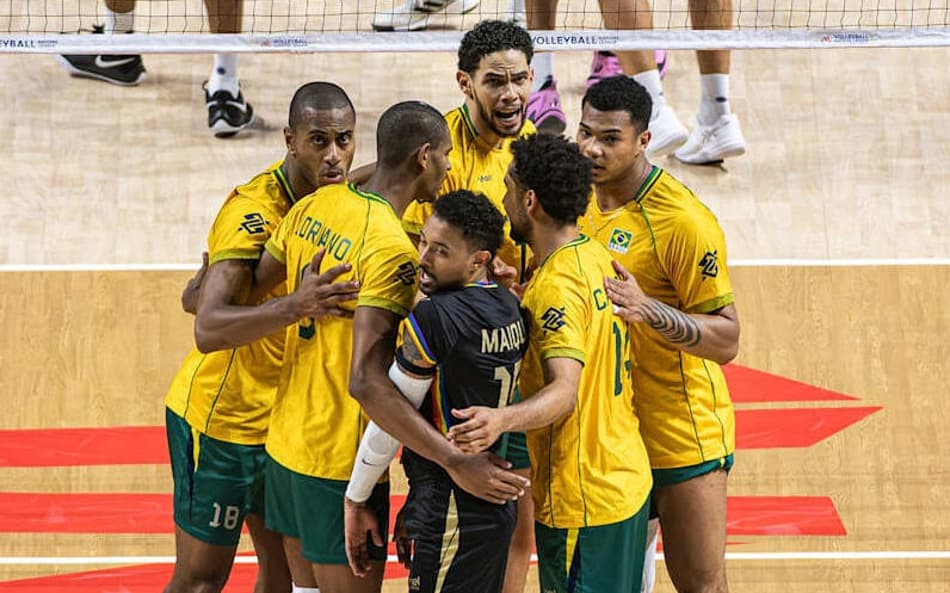 De camisas amarelas e shorts verdes, jogadores do Brasil se reúnem na quadra após marcarem ponto contra a França na VNL 2026