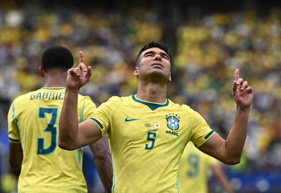 Casemiro de olhos fechados com a camisa da Seleção Brasileira apontando para o céu gol marcado
