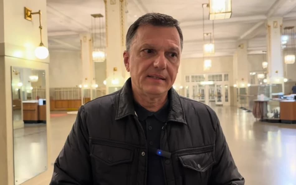 Mauro Cezar de casaco preto e blusa preta olhando para o lado