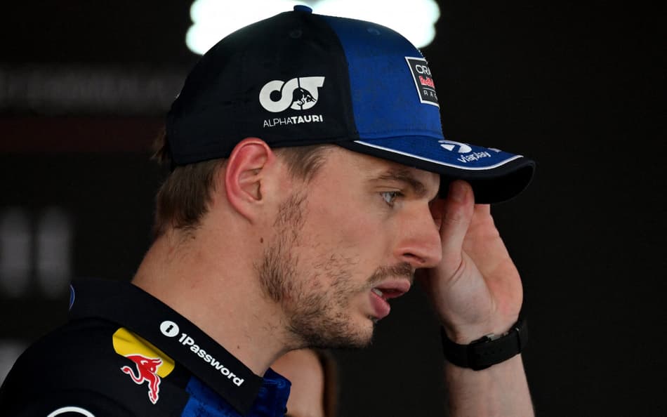 Max Verstappen fala com a imprensa e leva a mão esquerda a seu boné