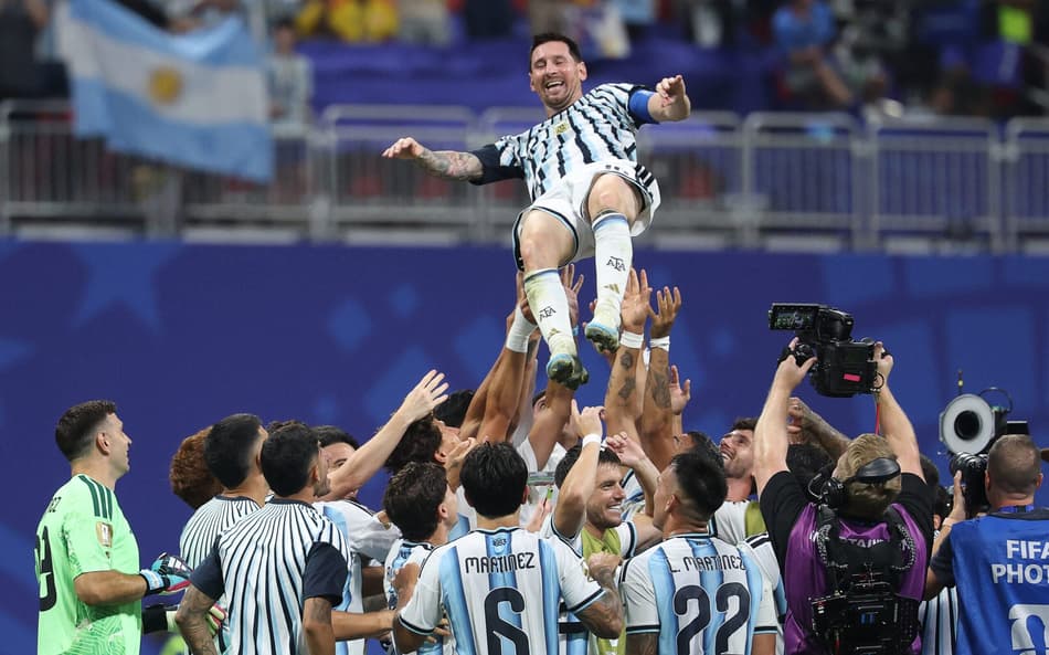 Messi sorridente é levantado por companheiros de time após vitória de virada da Argentina (Foto: Odd ANDERSEN / AFP)