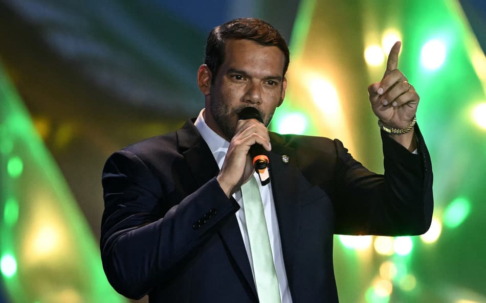 De terno, Samir Xaud, presidente da CBF, fala ao microfone com o dedo levantado durante convocação da Seleção Brasileira para a Copa do Mundo 2026