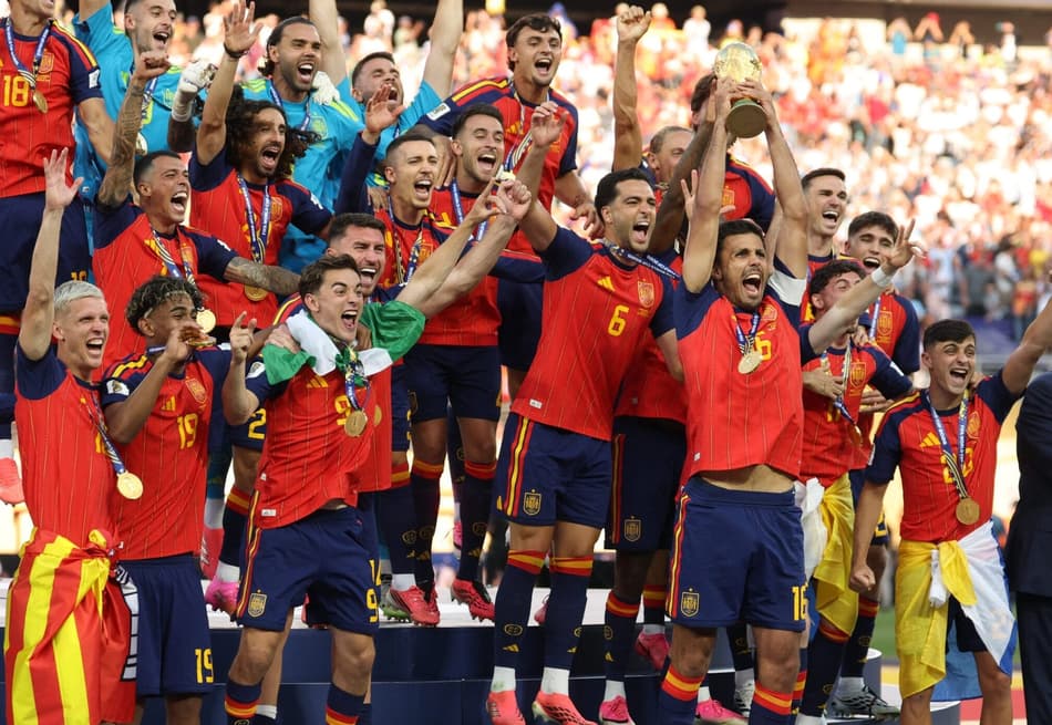 O meio-campista espanhol número 16, Rodri, ergue o troféu com seus companheiros de equipe após a vitória na final da Copa do Mundo de 2026 entre Espanha e Argentina, no Estádio Nova York/Nova Jersey, em East Rutherford, em 19 de julho de 2026
