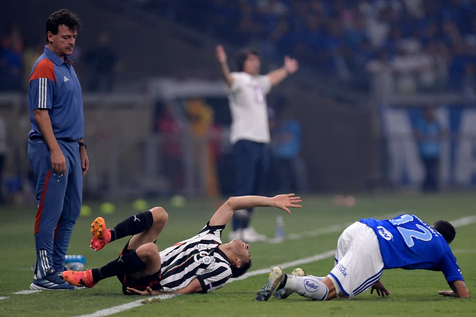 Técnico Fernando Diniz observa Matias Espinoza e William em Cruzeiro x Libertad. (foto: DOUGLAS MAGNO / AFP)