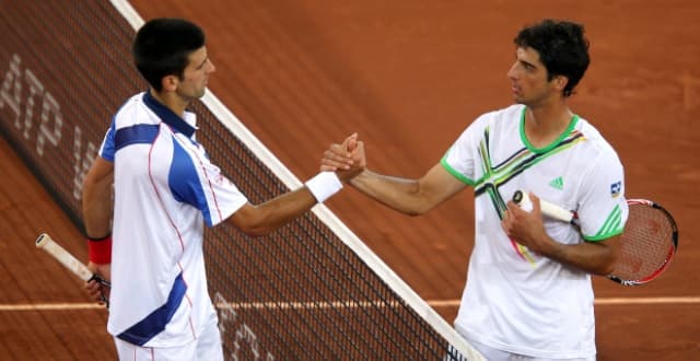 Thomaz Bellucci e Novak Djokovic se cumprimentam após jogo histórico