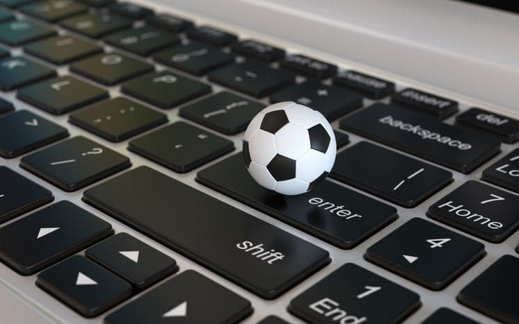 Football ball, soccer ball, on laptop keyboard