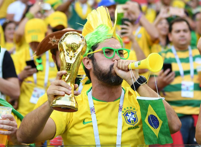 Jovem vestindo a camisa do uniforme oficial da seleção brasileira de  futebol na copa do catar 2022 e com a bandeira do brasil em foto de estúdio  fã brasileiro